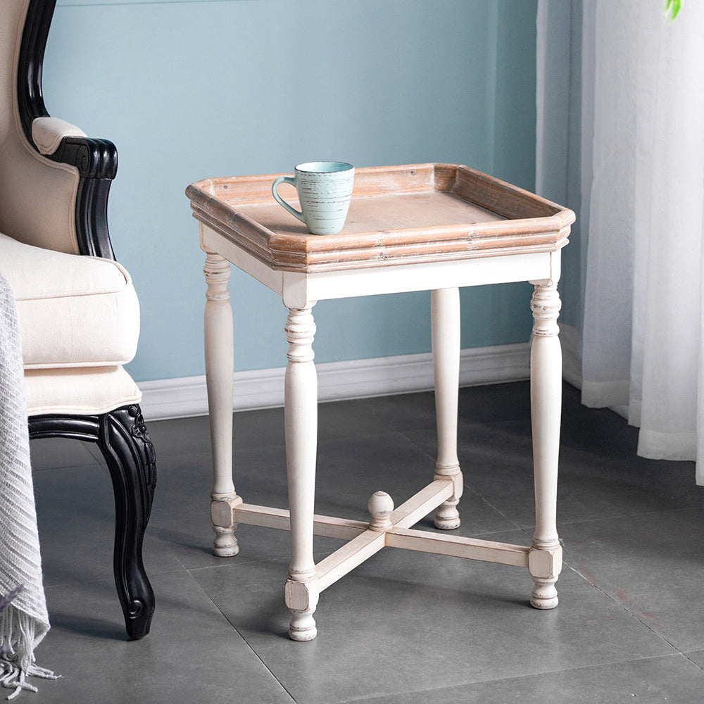 Small wooden side table with a tray and cup against a light blue wall.