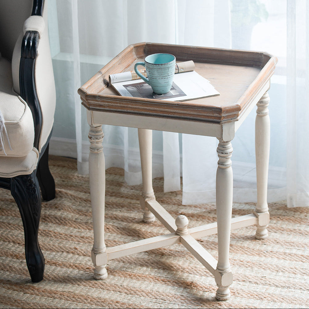 Small wooden table with a cup on a striped rug, next to a chair with a white cushion.