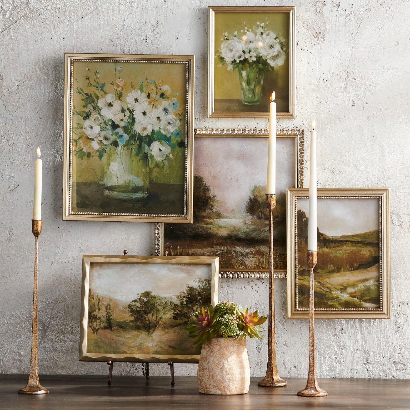 Collection of framed paintings and decorative items on a wall with a rustic texture.