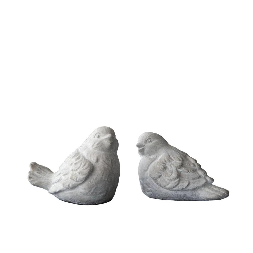 Two gray bird figurines on a book with a black background