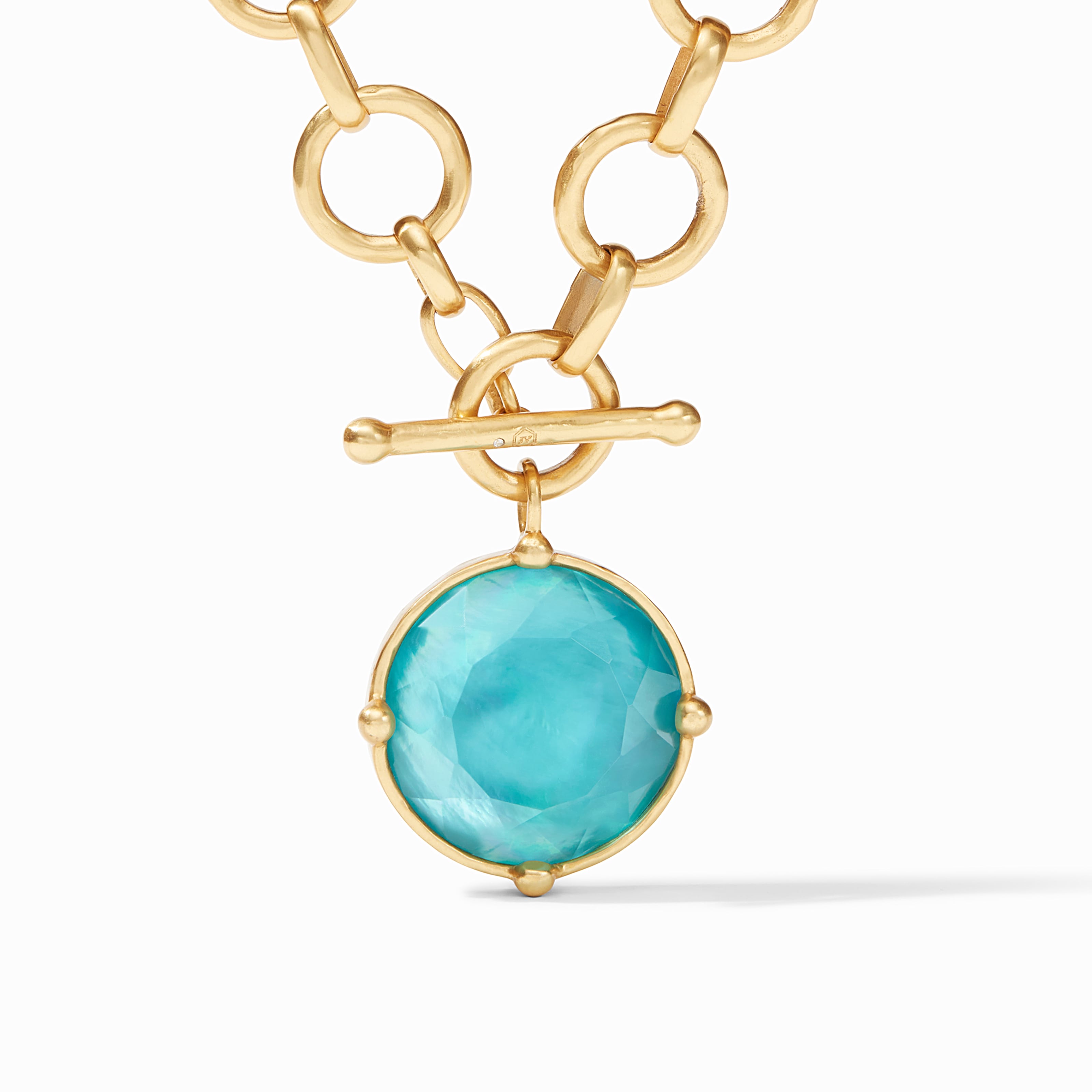 Gold necklace with a turquoise pendant on a white background