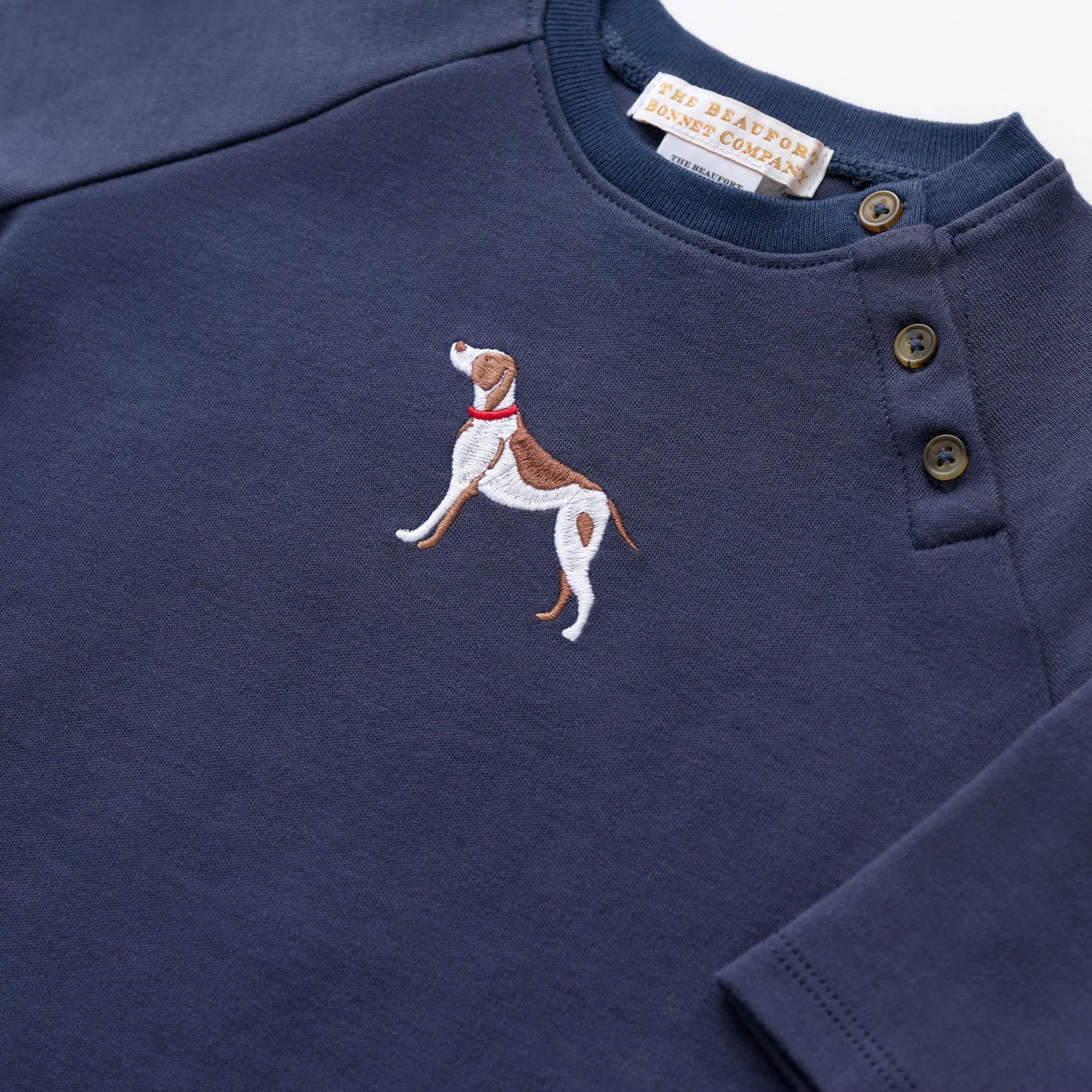 Navy blue long-sleeve shirt with embroidered dog design on a white background