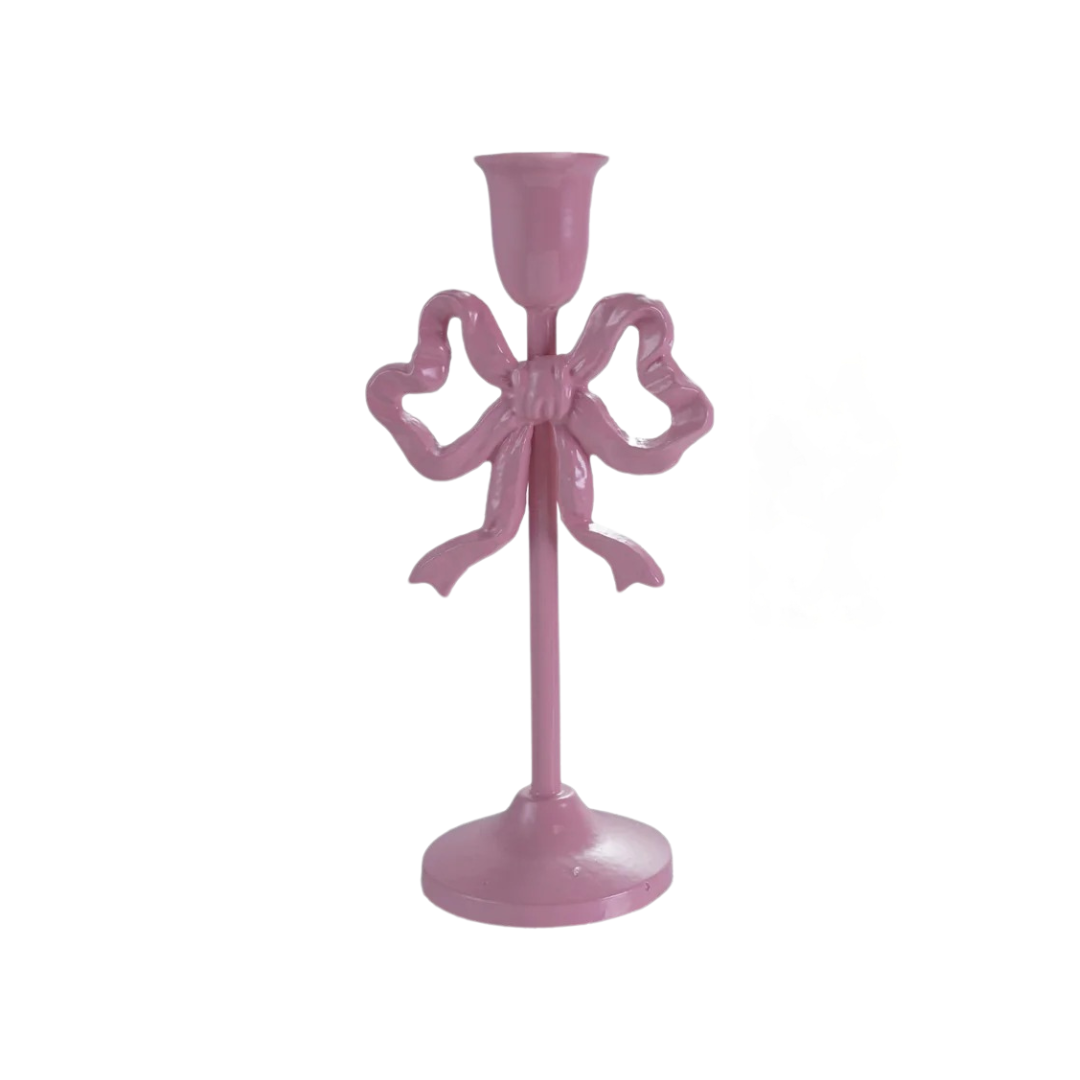 Pink candle holder with bow design on a white background