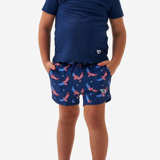 Child wearing navy blue t-shirt and shorts with American flag pattern on a white background