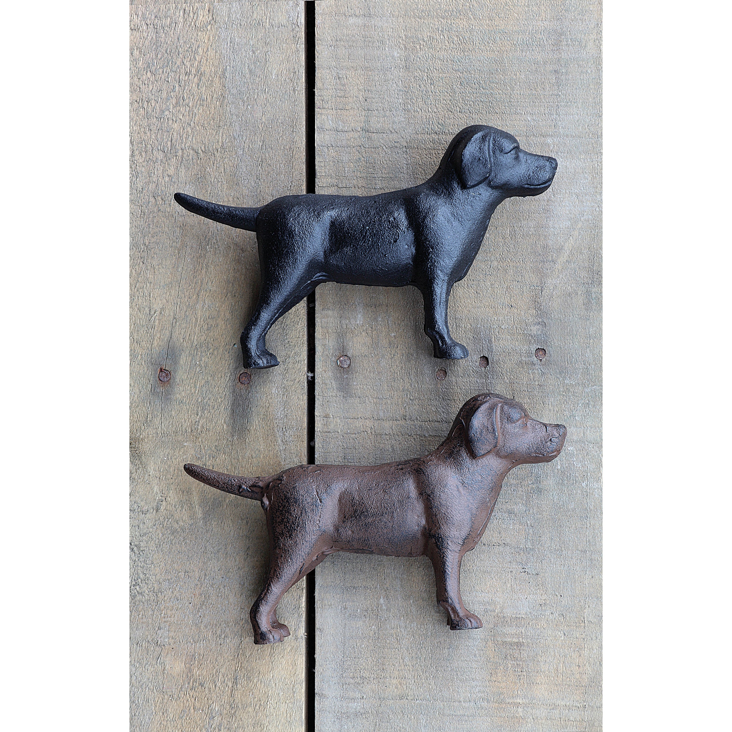 Two cast iron dog sculptures on a wooden background