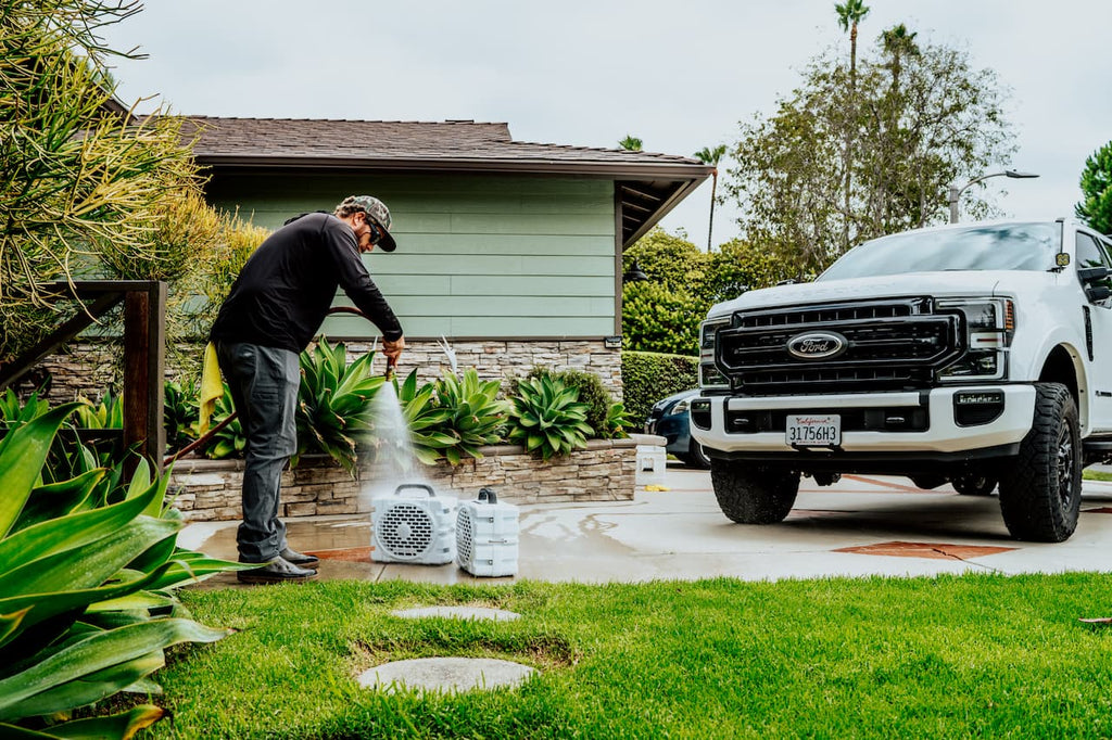 A lifestyle photo from a guy washing his Grande speakers in white in the front of his truck. #base-color_white
